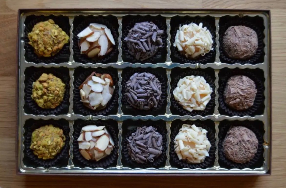 Assorted brigadeiros arranged in a gift box.