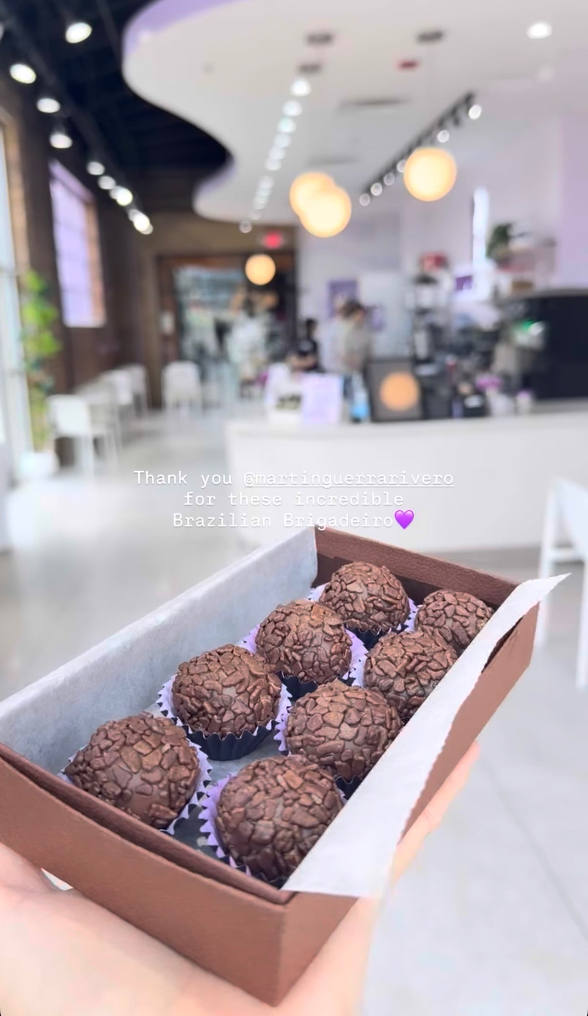 Four brigadeiros in colorful wrappers on a wooden surface.